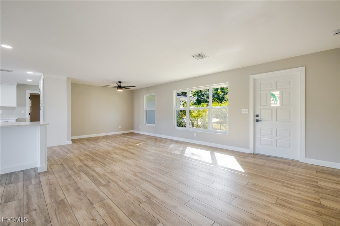 14502 Riverside Drive Fort Myers, FL 33905 - Photo 5 of 33 a view of an empty room with wooden floor and a window