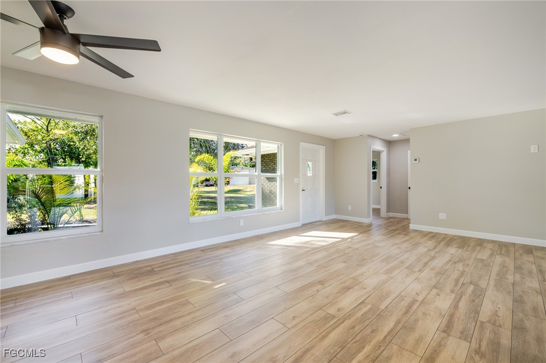 14502 Riverside Drive Fort Myers, FL 33905 - Photo 6 of 33 a view of an empty room with wooden floor and a window