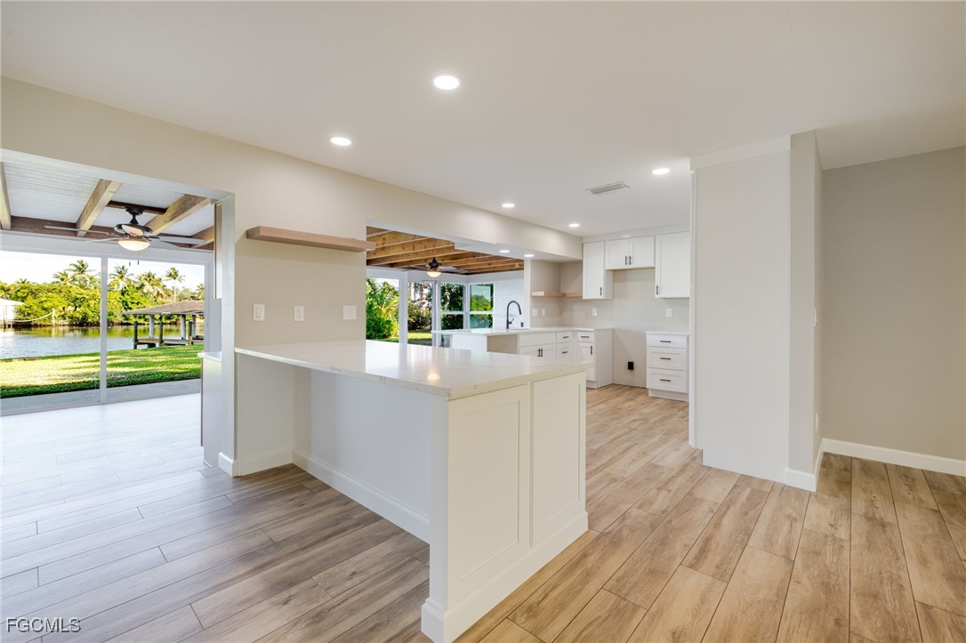 14502 Riverside Drive Fort Myers, FL 33905 - Photo 8 of 33 a kitchen with stainless steel appliances kitchen island wooden floors stove and refrigerator