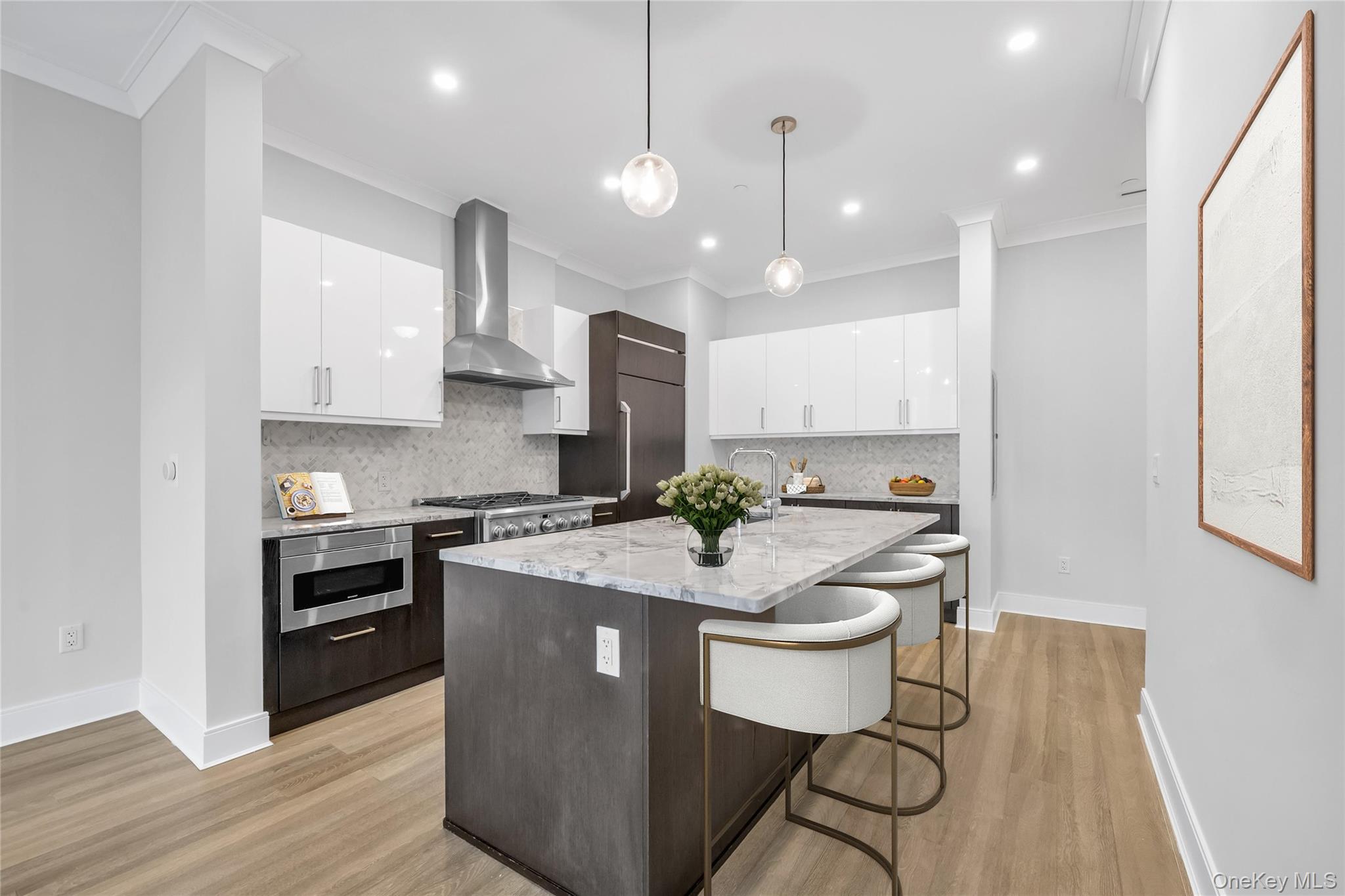 100 Garvies Point Road, Unit 1238 Glen Cove, NY 11542 - Photo 14 of 41 a large kitchen with kitchen island a stove a sink a refrigerator and white cabinets with wooden floor