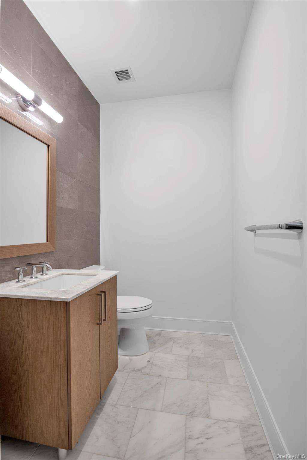 100 Garvies Point Road, Unit 1238 Glen Cove, NY 11542 - Photo 19 of 41 a bathroom with a sink a toilet and a mirror