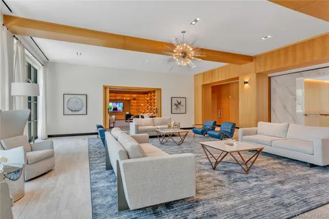 a living room with furniture a floor to ceiling window and a flat screen tv