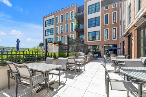 a view of a patio with couches table and chairs and potted plants