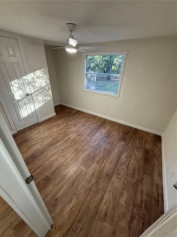 a view of empty room with wooden floor