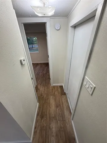 a large kitchen with stainless steel appliances a large counter top and a wooden floors