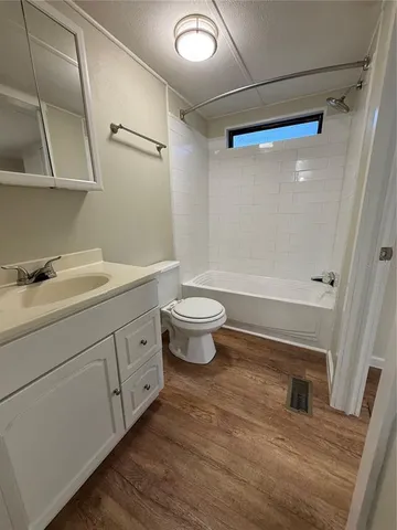 a room with wooden floor and ceiling fan