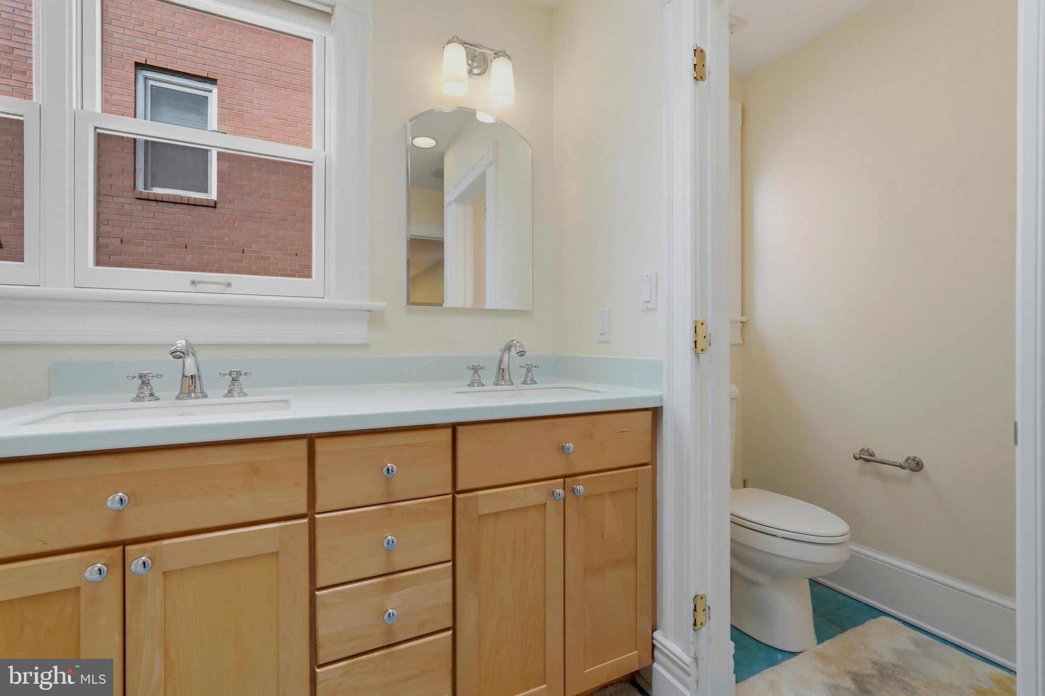 1002 N Street Northwest Washington, DC 20001 - Photo 23 of 33 a bathroom with a granite countertop sink a toilet and a mirror