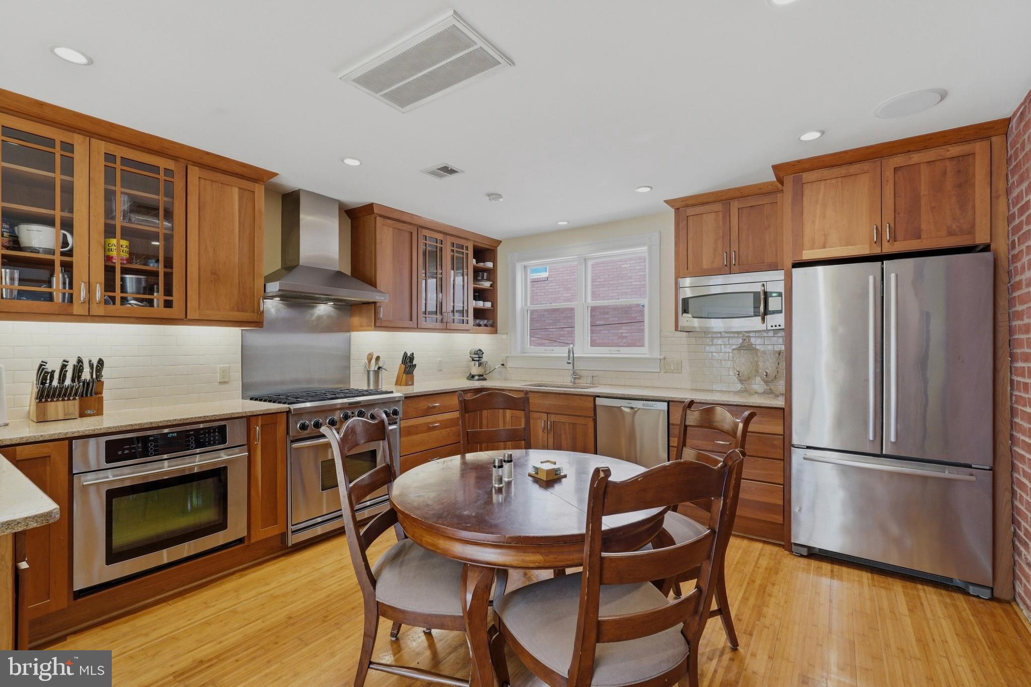 1002 N Street Northwest Washington, DC 20001 - Photo 10 of 33 a kitchen with stainless steel appliances granite countertop a stove a sink dishwasher a refrigerator with a dining table and chairs