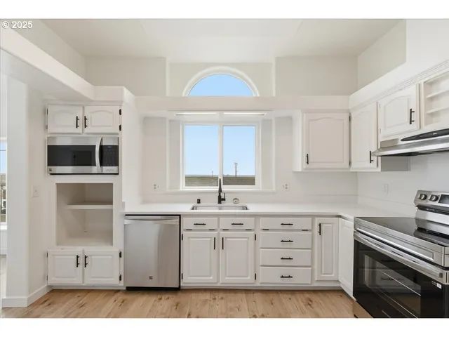 a kitchen with stainless steel appliances a sink stove and cabinets