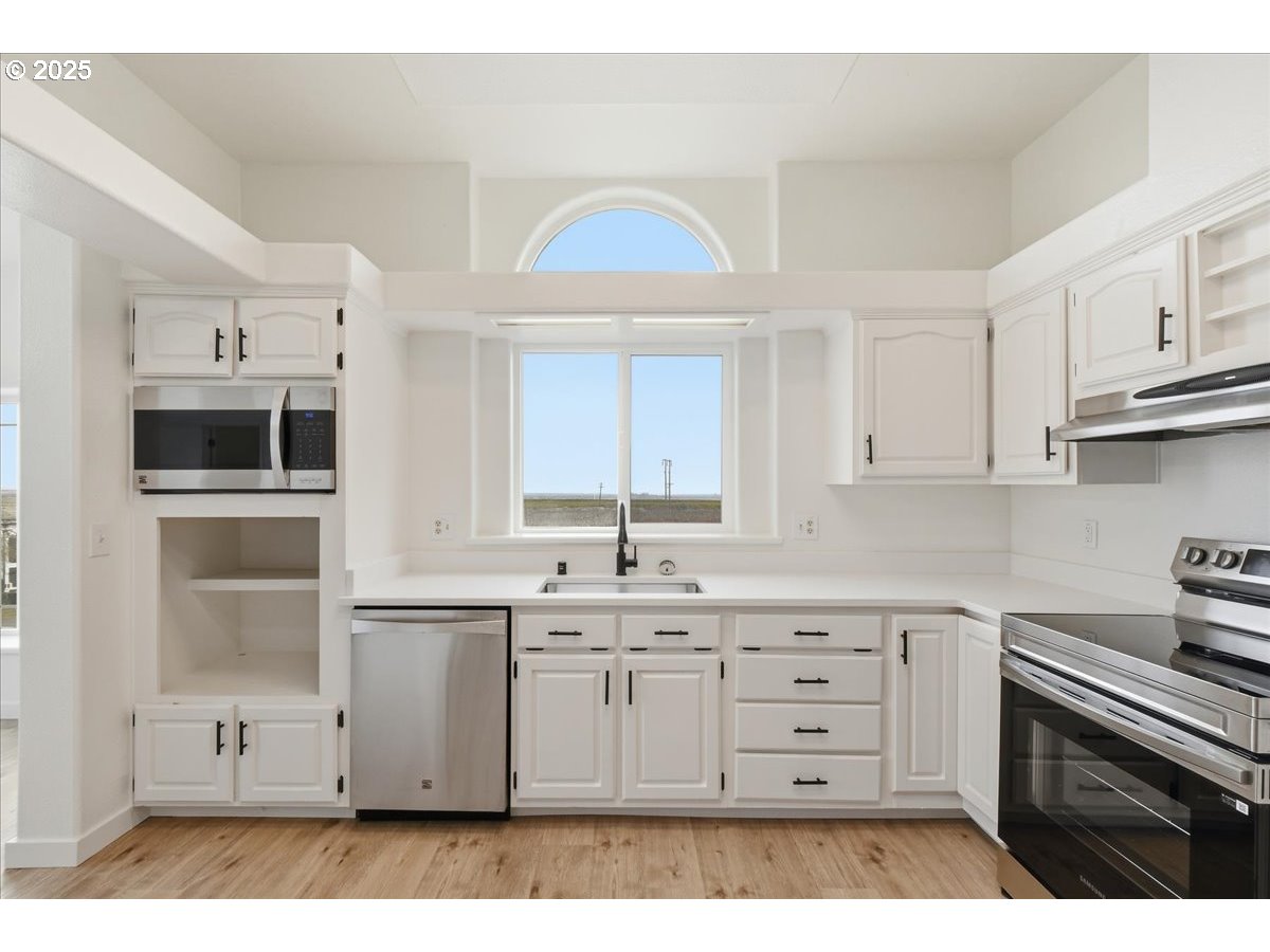 499 Alderdale Road Prosser, WA 99350 - Photo 16 of 41 a kitchen with stainless steel appliances a sink stove and cabinets