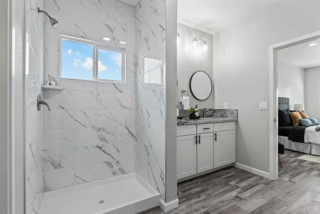 a bathroom with a granite countertop sink a mirror and a bathtub