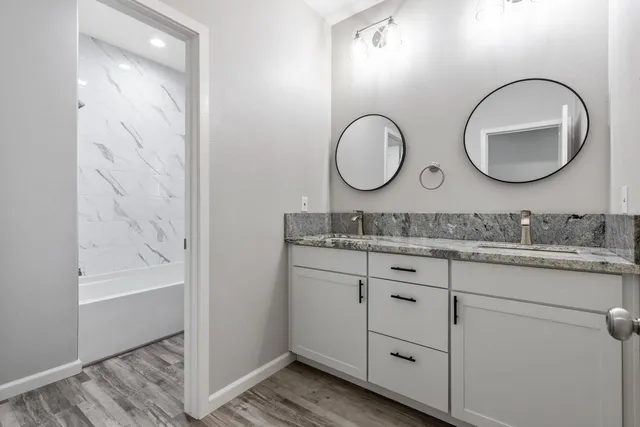 a bathroom with a granite countertop sink mirror and vanity