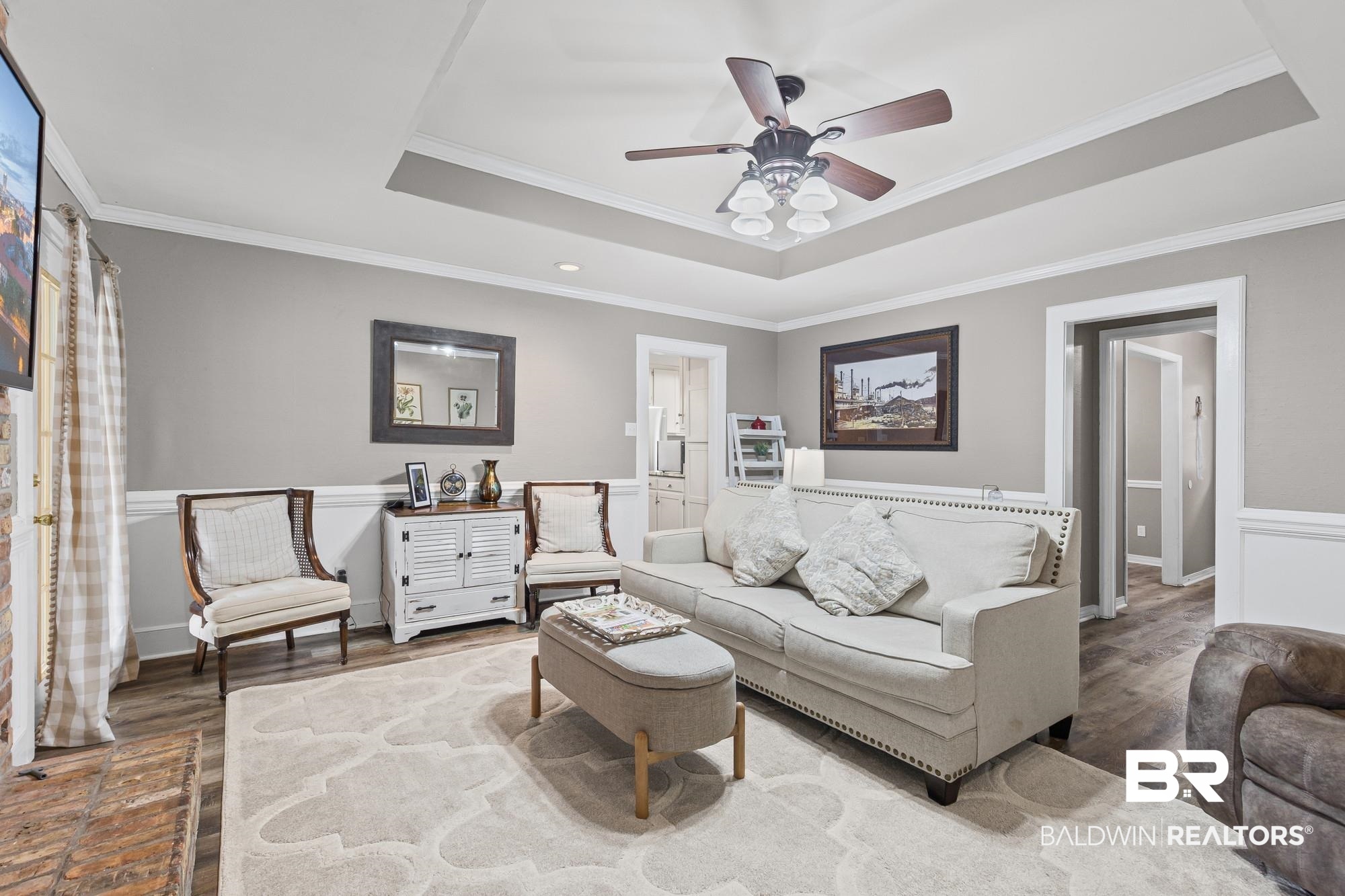 6609 Blakeley Court Mobile, AL 36695 - Photo 12 of 28 Living room featuring crown molding, wood finished floors, ceiling fan, and a tray ceiling