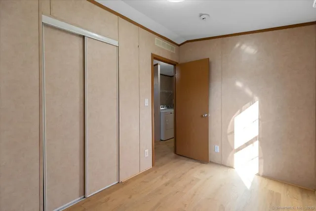 a view of hallway with a large window and wooden floor