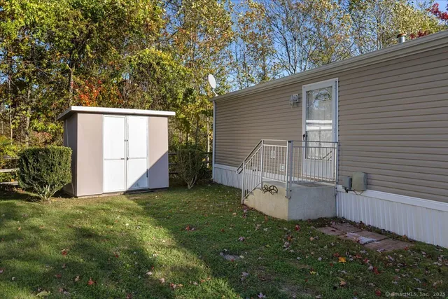 a view of a house with backyard and a tree