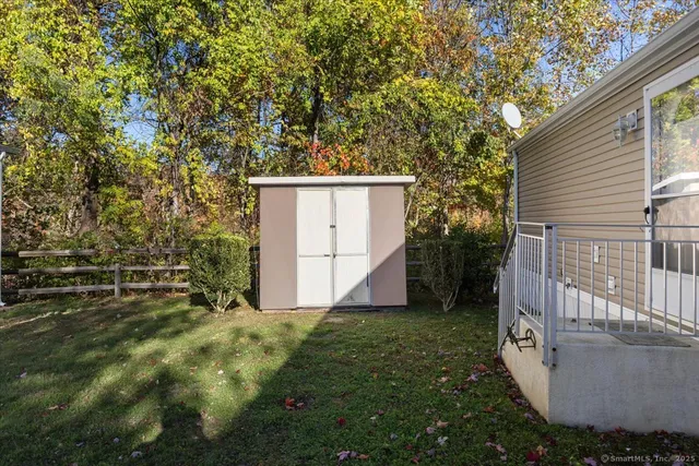 a view of a backyard with barn and wooden fence