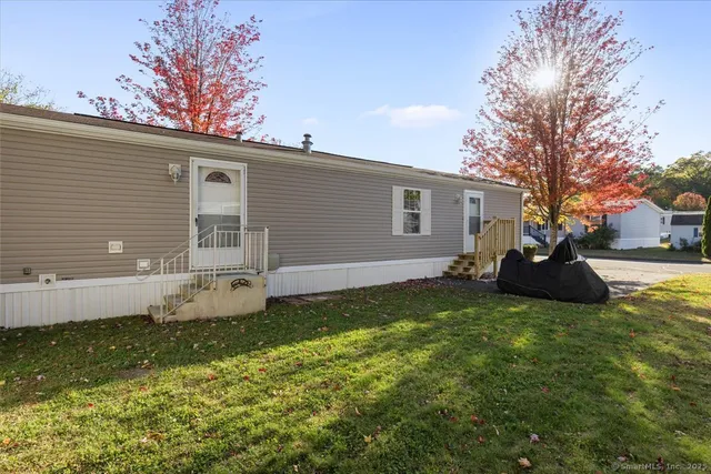 a view of a house with backyard and sitting area