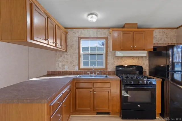 a kitchen with stainless steel appliances granite countertop a stove a sink and a microwave