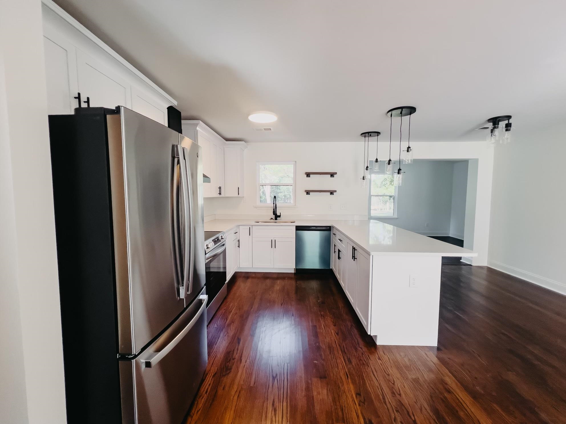 8515 Epperson Mill Road Millington, TN 38053 - Photo 13 of 32 Kitchen with kitchen peninsula, stainless steel appliances, decorative light fixtures, dark hardwood / wood-style floors, and sink