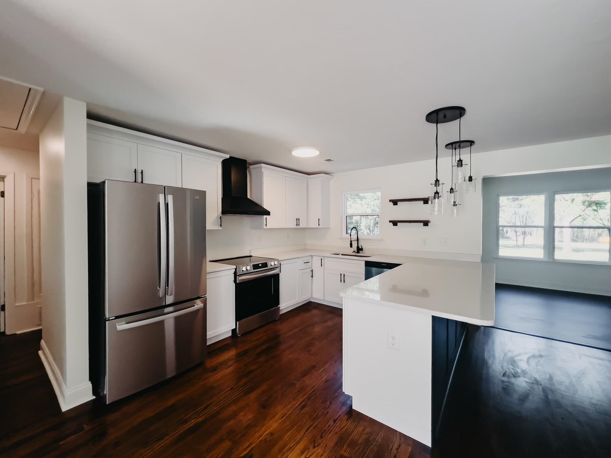 8515 Epperson Mill Road Millington, TN 38053 - Photo 14 of 32 Kitchen with dark wood-type flooring, kitchen peninsula, hanging light fixtures, wall chimney exhaust hood, and stainless steel appliances