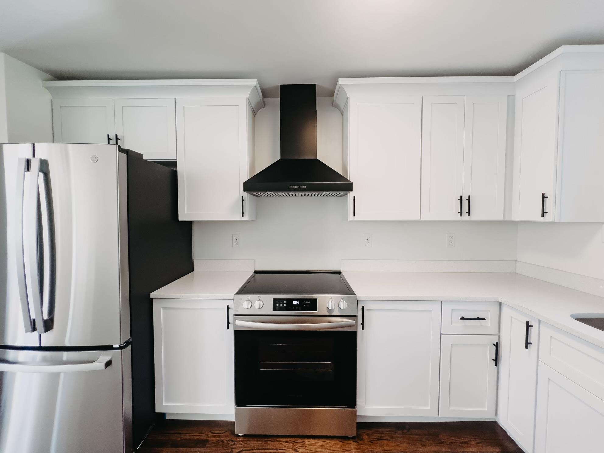8515 Epperson Mill Road Millington, TN 38053 - Photo 10 of 32 Kitchen with appliances with stainless steel finishes, wall chimney exhaust hood, white cabinetry, and dark hardwood / wood-style flooring