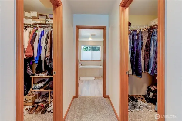 a view of walk in closet with clothes and shoes