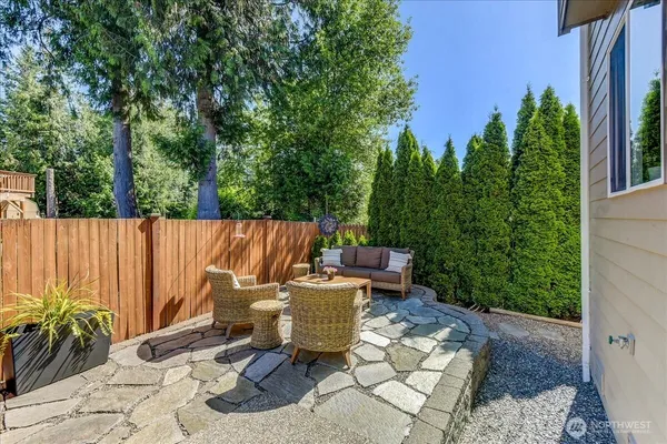 a view of a patio with table and chairs potted plants and a large tree