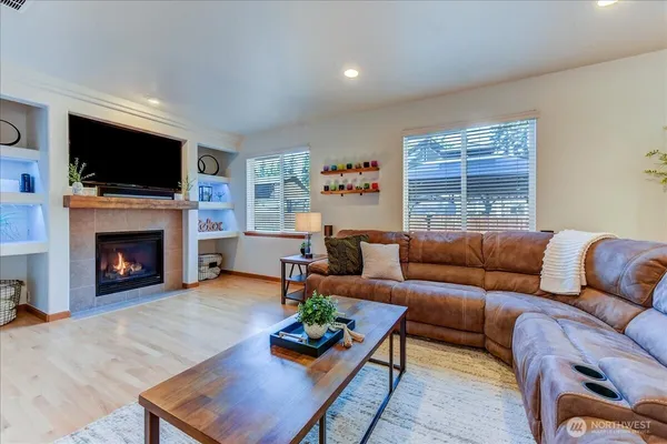 a living room with furniture a flat screen tv and a fireplace
