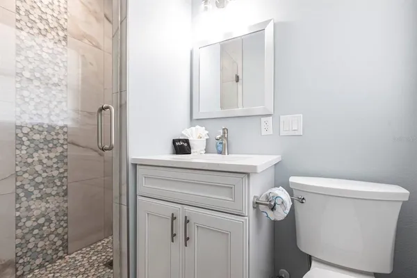 a bathroom with a sink a toilet and shower