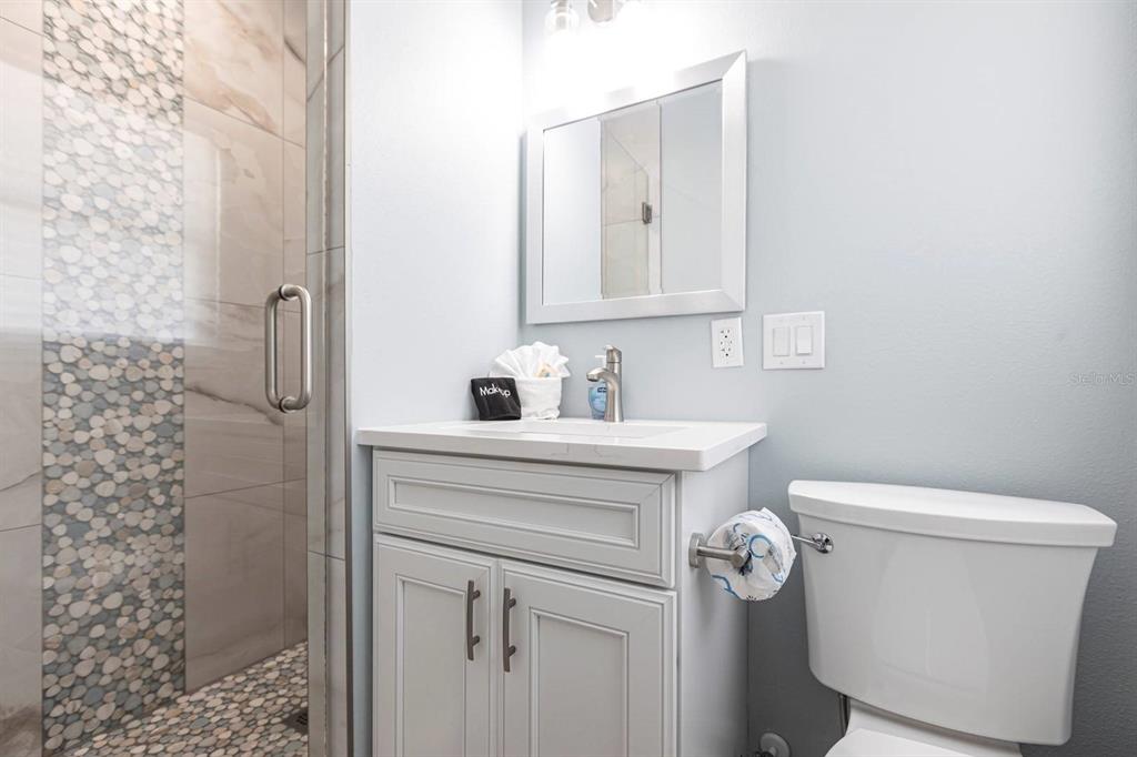 6020 Midnight Pass Road, Unit 64 Sarasota, FL 34242 - Photo 11 of 14 a bathroom with a sink a toilet and shower