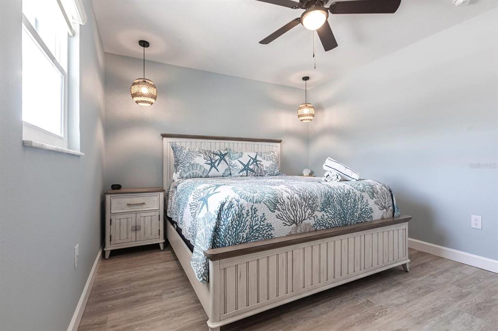 6020 Midnight Pass Road, Unit 64 Sarasota, FL 34242 - Photo 7 of 14 a bedroom with a bed and ceiling fan