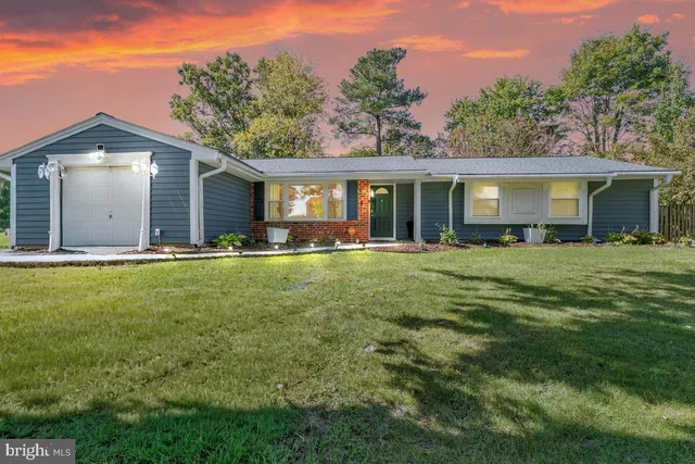 a front view of house with yard and green space