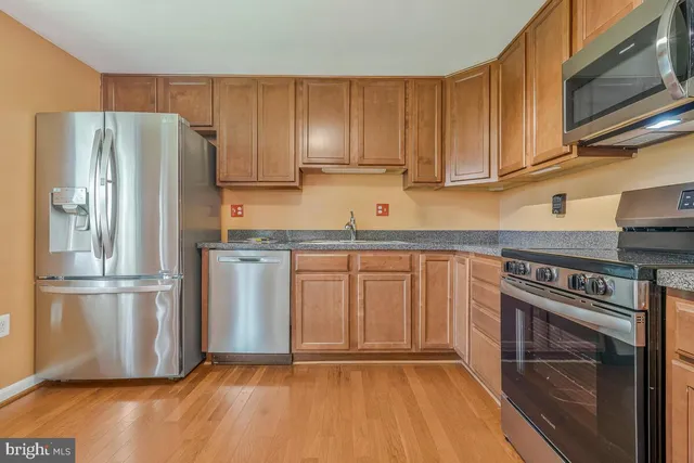 a kitchen with granite countertop wooden cabinets and stainless steel appliances