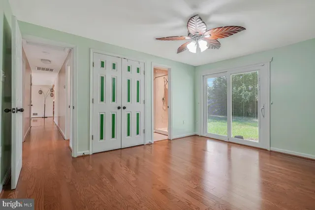 a view of a hallway with wooden floor and chandelier