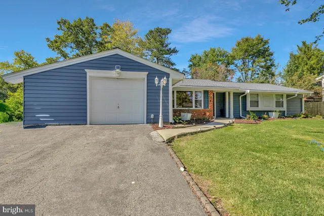 a view of a house with a yard potted plants and a table