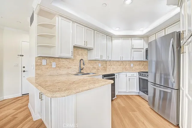 a kitchen with refrigerator cabinets and wooden floor