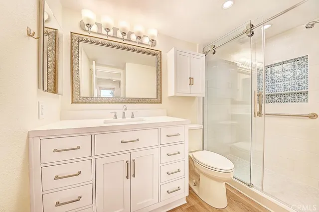 a bathroom with a toilet a sink a large mirror and shower