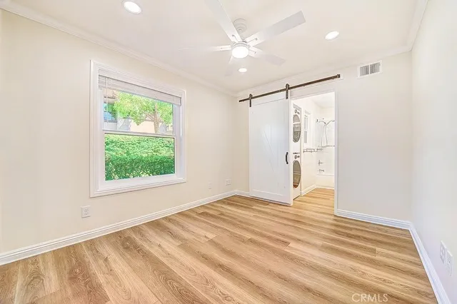 a view of empty room with wooden floor and fan