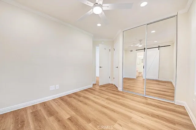 a view of a livingroom with wooden floor and a ceiling fan