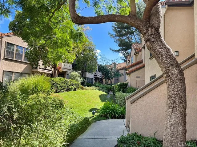 a view of a house with a yard and potted plants