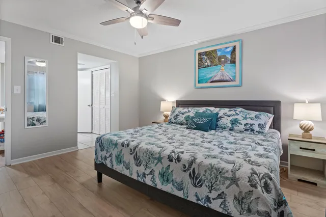 a bedroom with a bed and painting on the wall