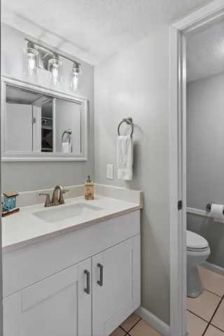 a bathroom with a granite countertop sink a toilet and a mirror