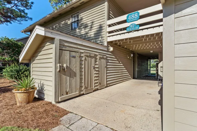 a view of a house with a potted plant and floor to ceiling window