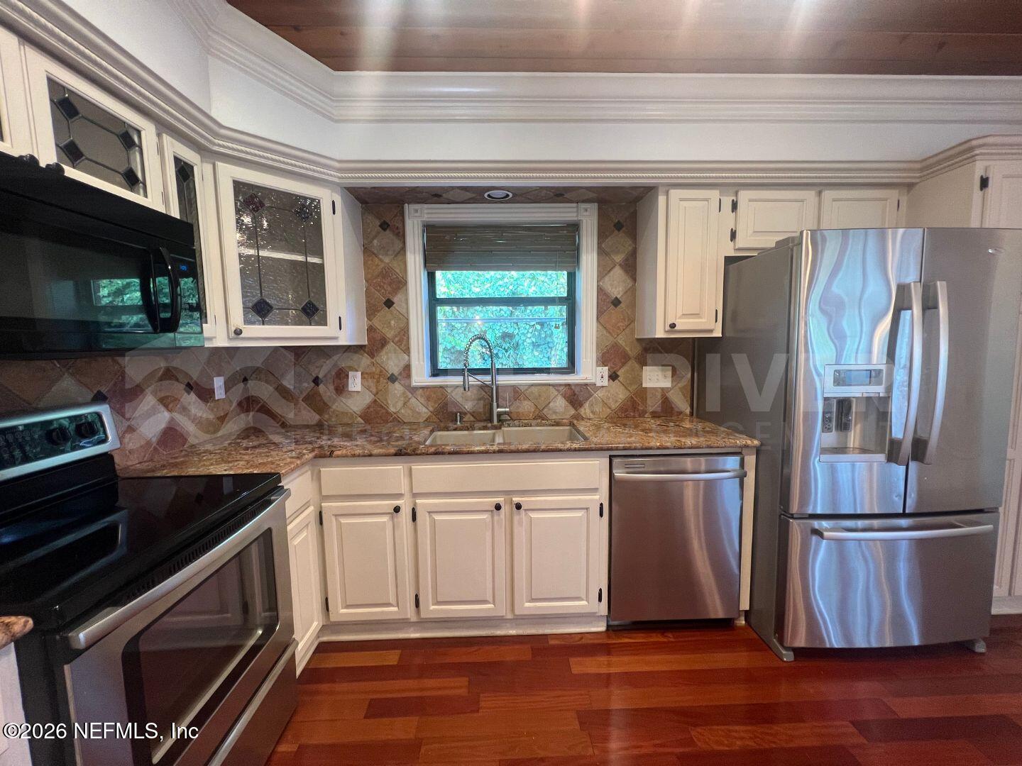 174 Eventide Drive Fleming Island, FL 32003 - Photo 20 of 60 a kitchen with stainless steel appliances granite countertop a refrigerator and a stove