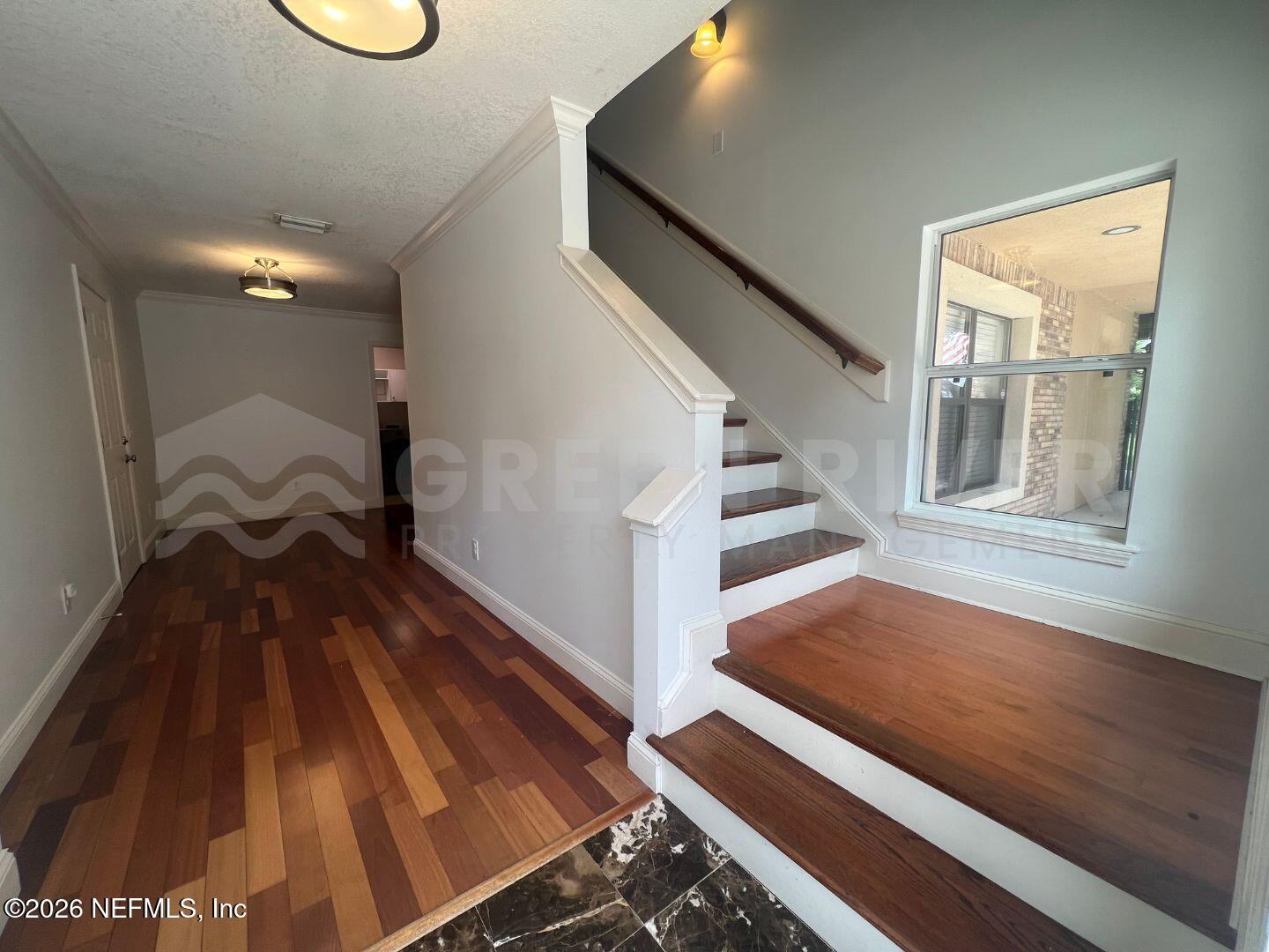 174 Eventide Drive Fleming Island, FL 32003 - Photo 5 of 60 a view of a hallway with wooden floor and staircase