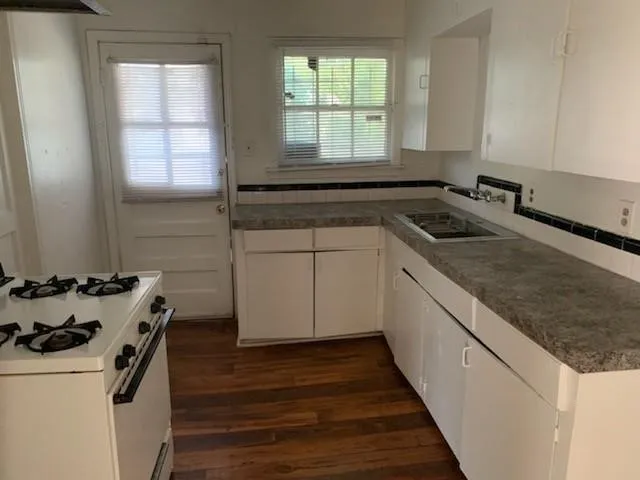 a kitchen with a sink stove and cabinets