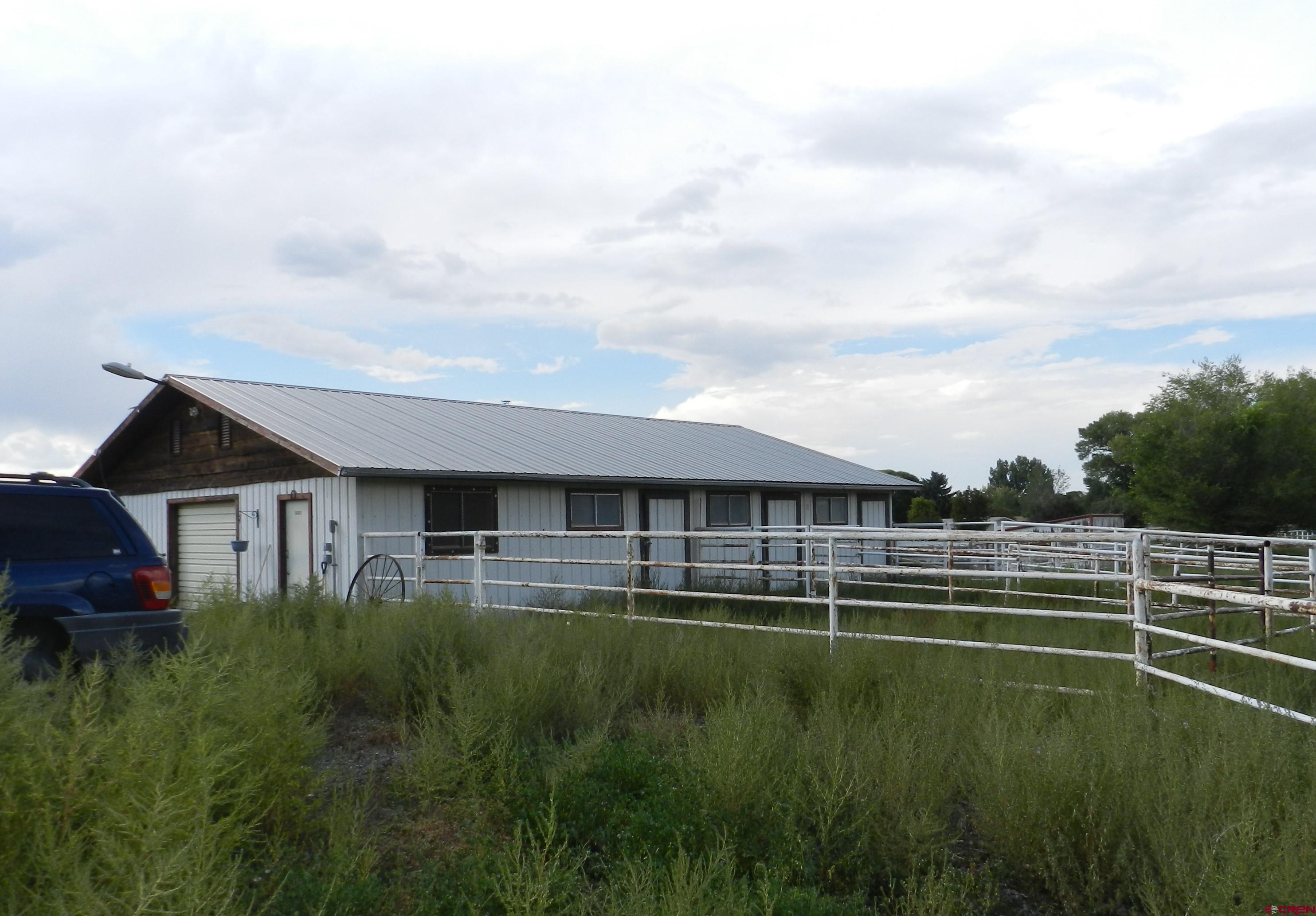 755 Spring Creek Road Montrose, CO 81403 - Photo 8 of 33 a view of a big house with a big yard and large trees