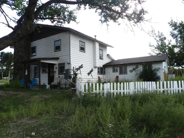 a view of a house with a yard and deck