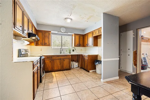 a kitchen with stainless steel appliances granite countertop a refrigerator and a stove top oven