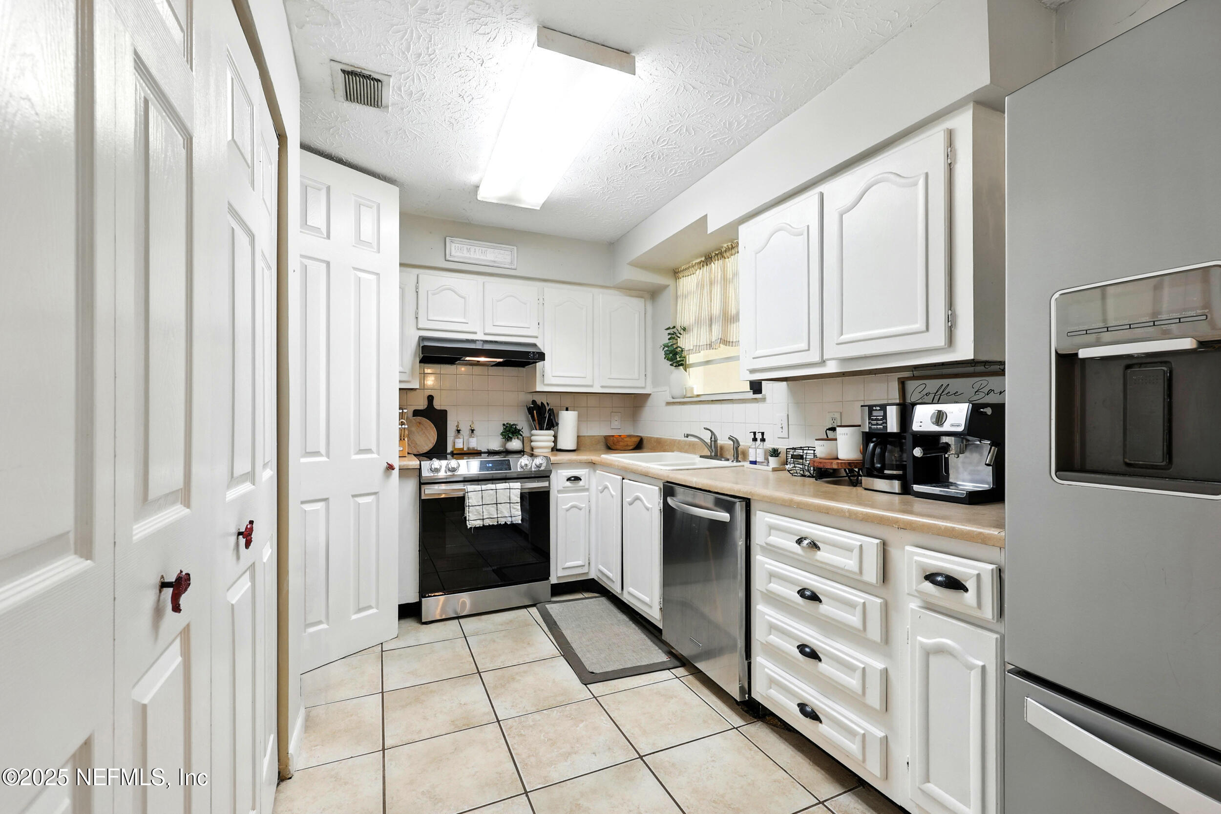 11599 Lake Ride Drive Jacksonville, FL 32223 - Photo 13 of 38 a kitchen with stainless steel appliances granite countertop a stove a sink and a refrigerator